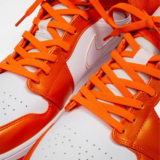Close-up of Coral Orange elastic shoelaces threaded through sneaker eyelets