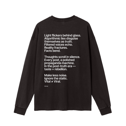 Washed black long‑sleeve back with white manifesto text block ending ‘Vital ≠ Viral’ and small ‘riot.nyc’ mark.