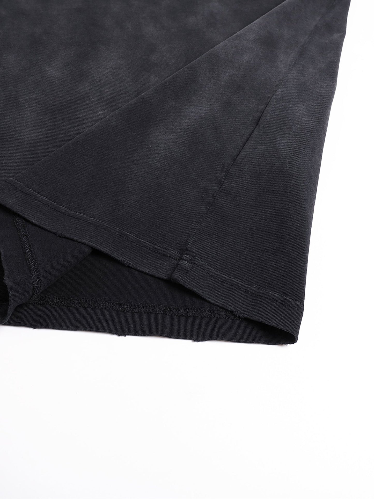 Detail shot of Bleed Electric A Human Story t-shirt fabric fold highlighting washed cotton texture and construction