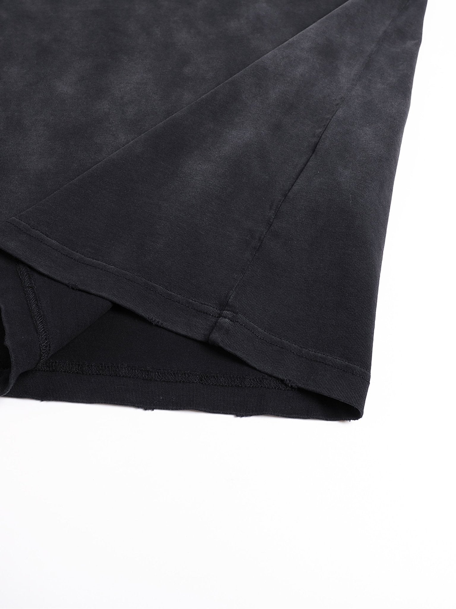 Detail shot of Bleed Electric A Human Story t-shirt fabric fold highlighting washed cotton texture and construction