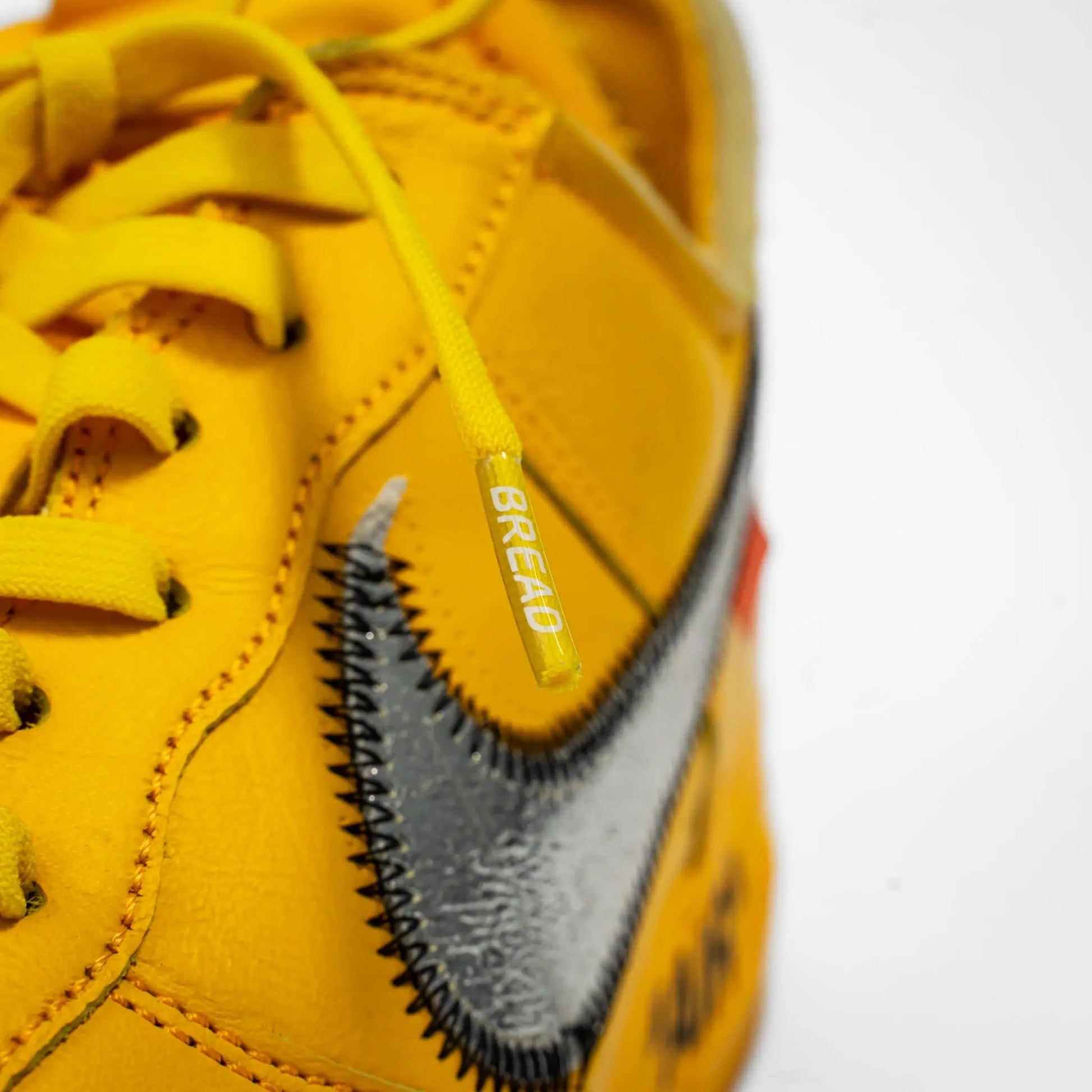 Bread branded aglet on Corona Yellow elastic shoelace close-up detail