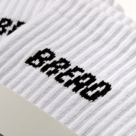 Close-up of Bread logo embroidered on white ribbed crew sock