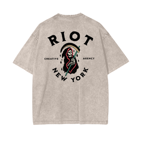 Back of apricot snow-washed oversized t-shirt featuring large RIOT Creative Agency reaper graphic with scythe