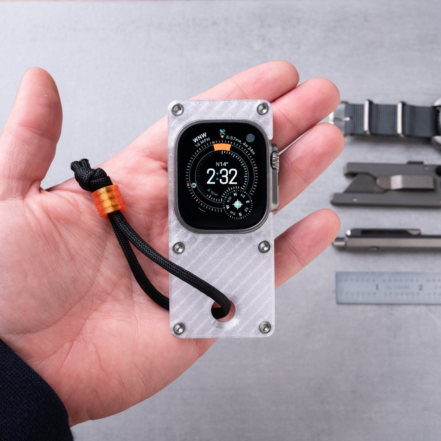 hand holding miniphone ultra ghost white Apple Watch Ultra case with orange lanyard bead