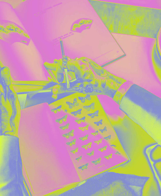 Tattooed hands flipping through a butterfly specimen book, overlaid with vibrant pink, yellow, and green gradient map effect