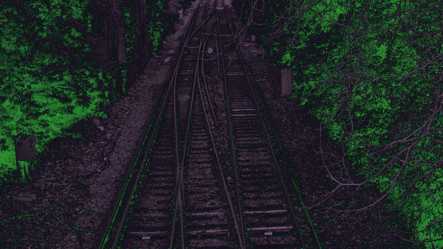 Railroad tracks surrounded by foliage with dark green and purple gradient overlay