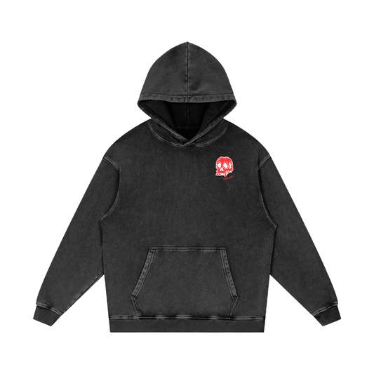 Front of black washed oversized hoodie featuring small red skull and crossbones RIOT crest on chest