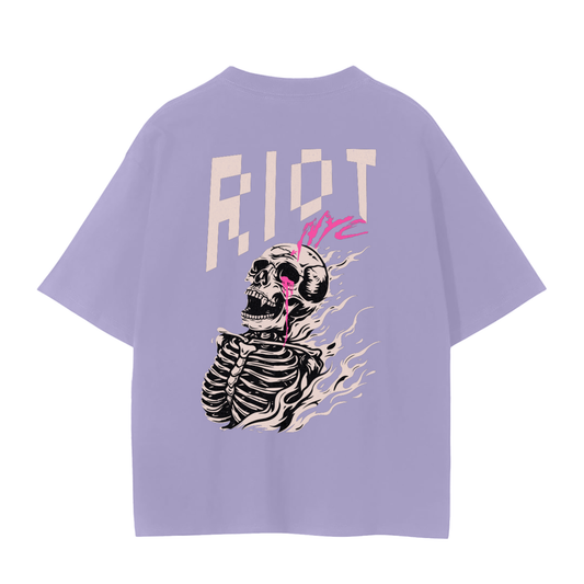 Lavender tee back with FLAMEBORN flaming skeleton skull, neon tear, RIOT block lettering, and NYC tag.
