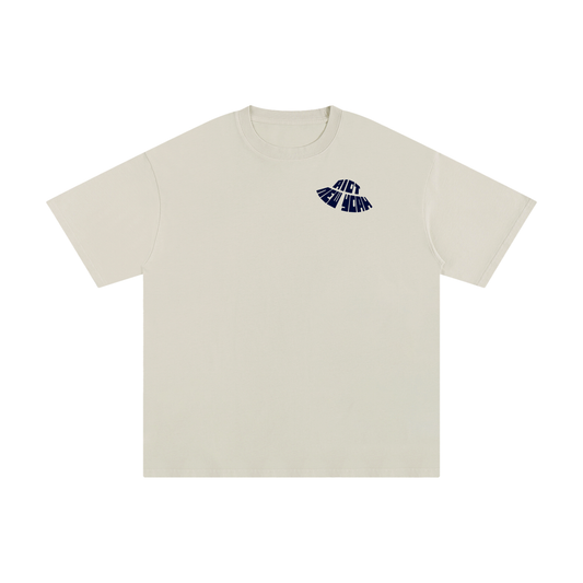 Sandstone beige tee front with small warped RIOT NEW YORK chest logo.