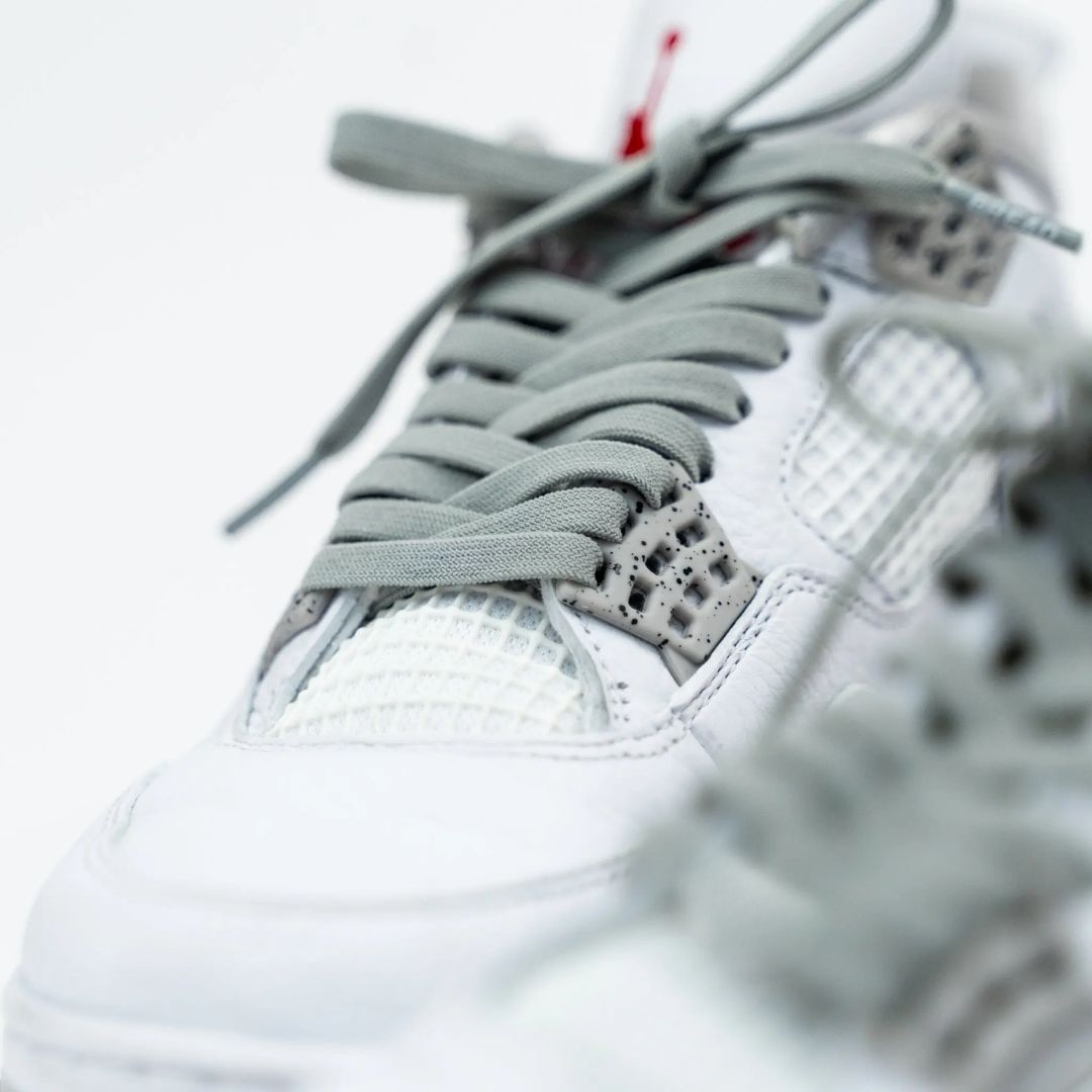 Close-up detail of Bread Vulture Gray laces threaded through white sneaker eyelets